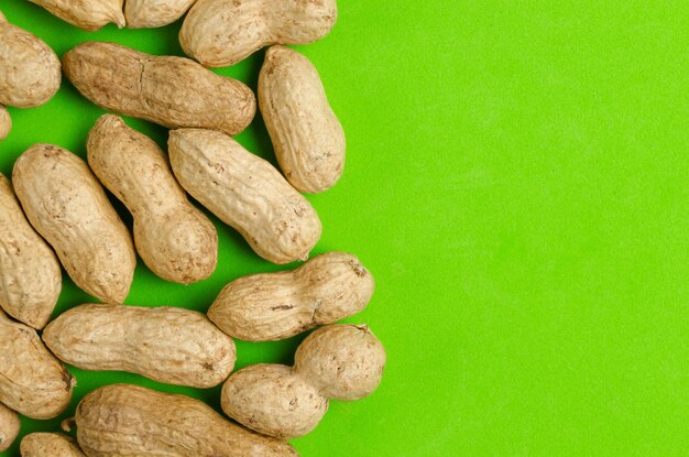 Peanuts on a bright green background concept for healthy eating