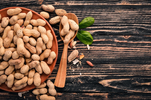 Peanuts on a dark wooden background Healthy snacks Top view Free space for text