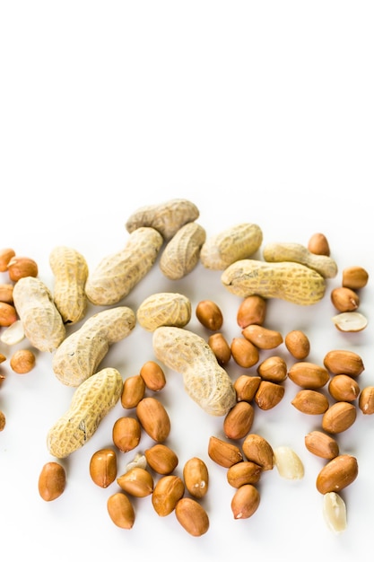 Peanuts peeled and in shells on a white background.