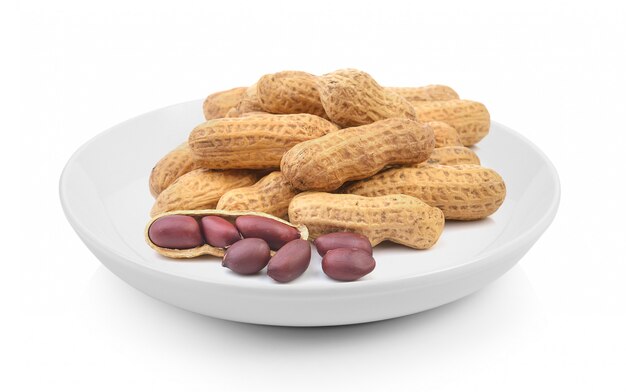 Peanuts in plate on white surface