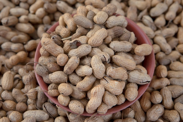 Photo peanuts in shell texture background. raw peanuts on display at a open air market.