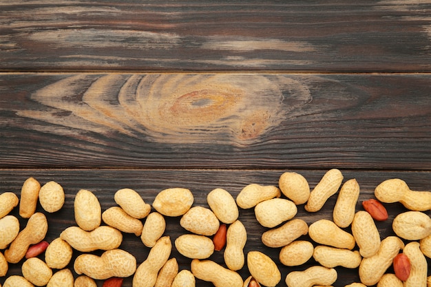 Peanuts in shells on brown background