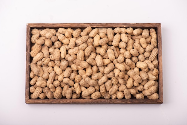 Photo the peanuts in the square plate are on a white background