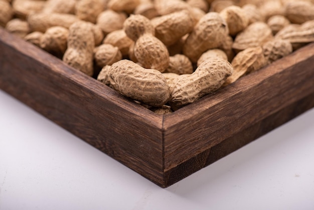 The peanuts in the square plate are on a white background