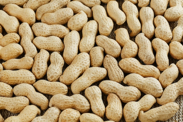 Peanuts in their shell textured food background.