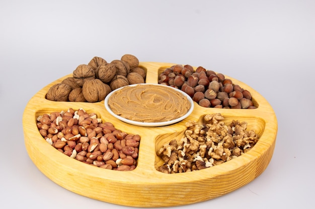 Peanuts walnuts and hazelnuts in a wooden box with compartments Three different types of nuts shelled and shelled decorative assortment and ready to eat Closeup isolated from above