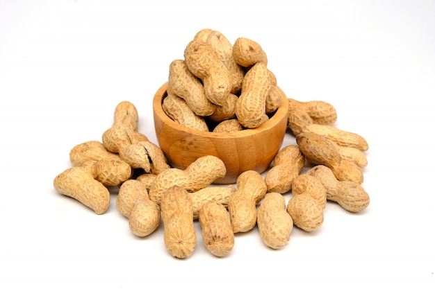 Peanuts in wooden bowl isolated on white