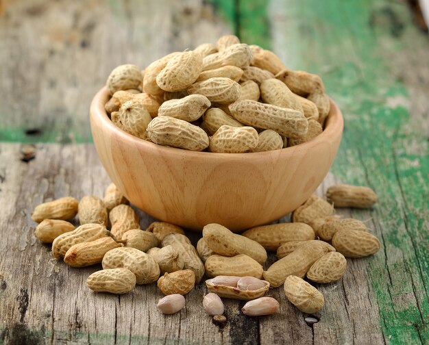 Peanuts in a wooden bowl on a wooden table