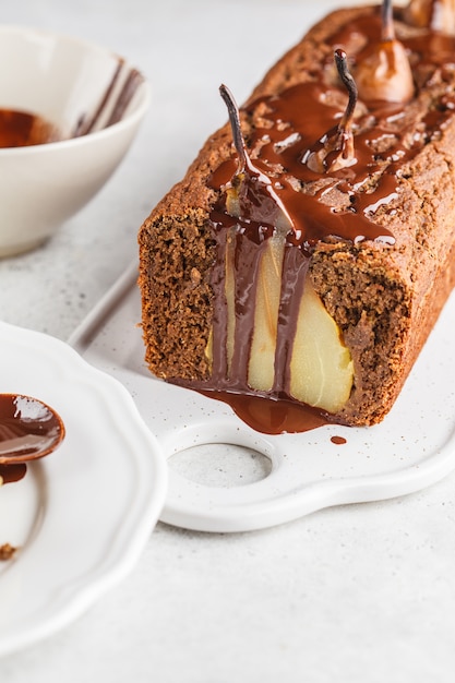 Pear and chocolate loaf on white board.