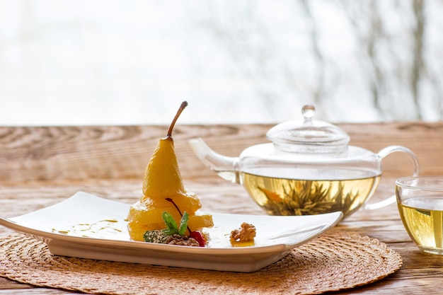 Pear dessert with herbal tea on table