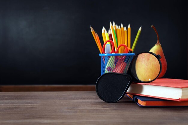 Pear magnifier and clock with books on desk background