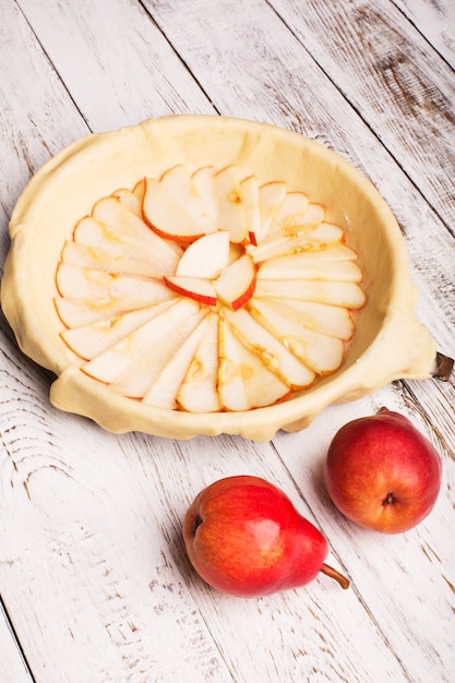 Pear pie preparation on wooden table 