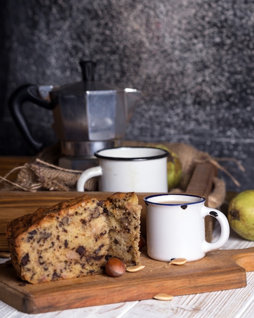 Грушевый пирог и чай с молоком на деревянном столе