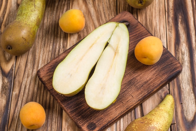 Pear and ripe apricots on a wooden table.