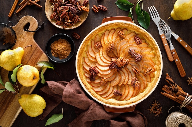 Pear tart pie or cake with fresh pears cinnamon and pecan nuts