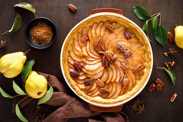 Pear tart pie or cake with fresh pears cinnamon and pecan nuts