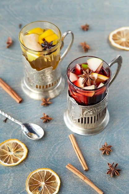 Pear tea and mulled wine on a wooden table, decorated with cinnamon, lemon and thyme