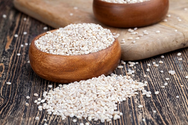 Pearl barley for cooking porridge, cereals are scattered in dishes on the table, cheap pearl barley is made from barley