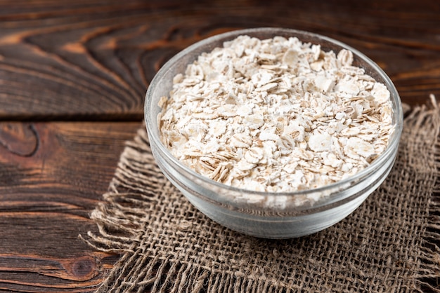 Pearl barley flakes on dark wooden