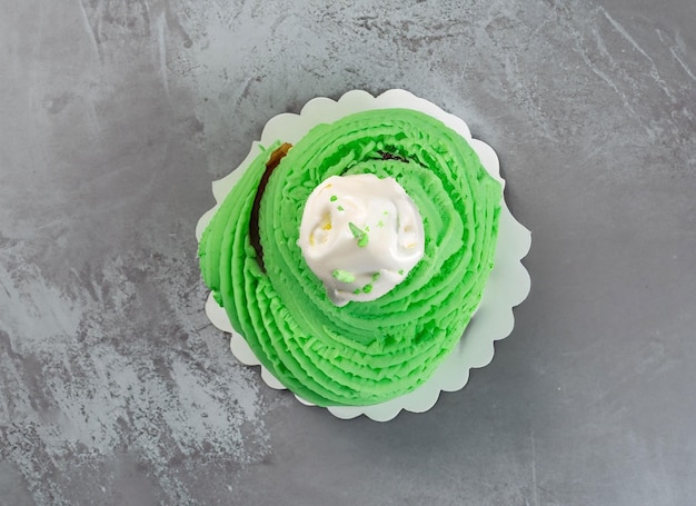 Pearl birthday cupcake with butter cream icing on gray background top view