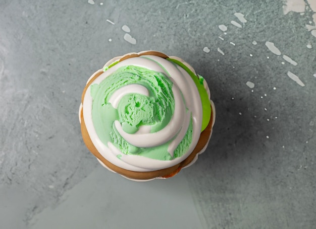 Жемчужный кекс на день рождения с глазурью из масляного крема на сером фоне, вид сверху