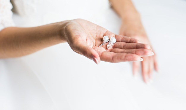 Pearl earring in hands