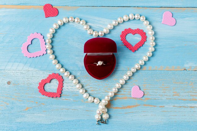 Pearl ring, necklace and heart on blue