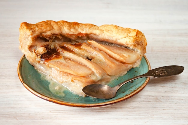 Photo pears and cheese pie cake on a plate on rustic white table