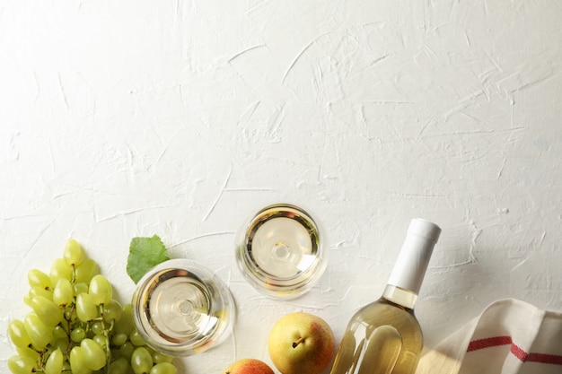 Pears, grape, bottle and glass with wine on white