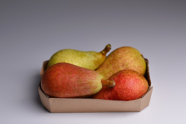 Pears isolated on grey background 
Yellow pear in a paper container Ecofriendly packaging