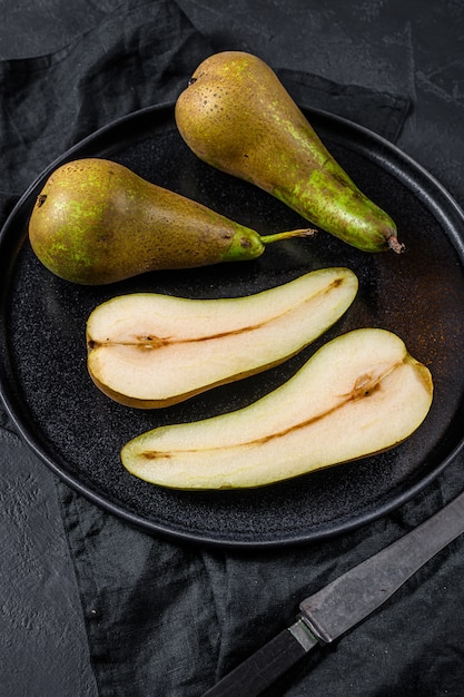 Pears and pear halves. Farm eco fruits. Black background. Top view