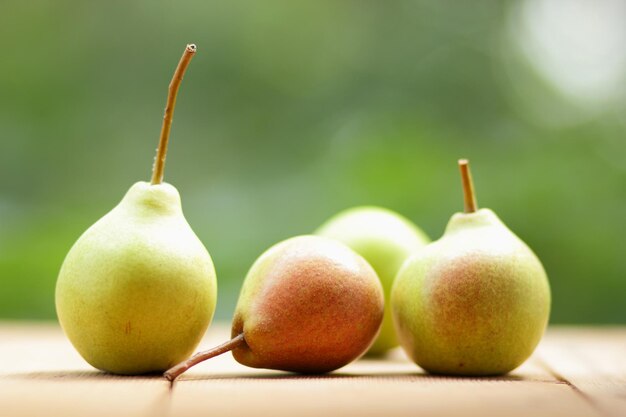 Pears on a wooden table on a blurred background Heap of ripe juicy pears on brown wooden table closeup