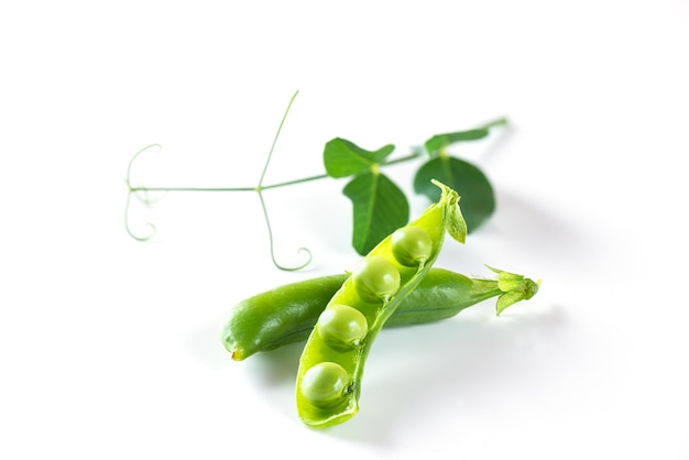 Peas in a pod with green leaves on a white background