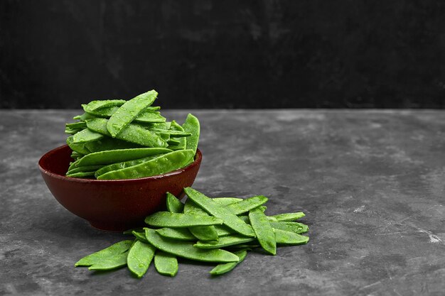 Peas in pods, reclining with a basket.