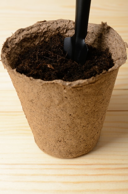 Peat pot with soil and shovel