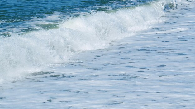 Photo pebble beach and sea waves waves washing the pebble beach calm sea surface slow motion