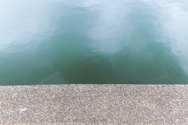 Pebble stone textured floor beside the river. The pattern floor show as seamless background.