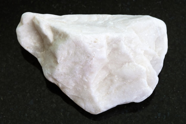 Pebble of white marble stone on dark background