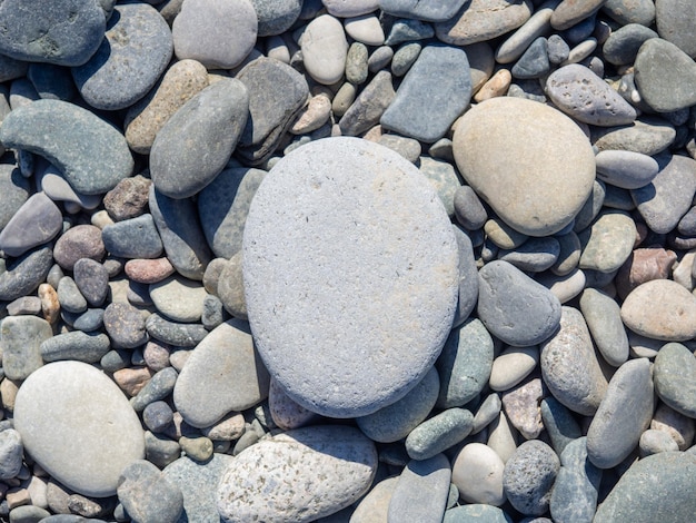 Pebbles on the beach Background from stones One large stone in the background of small ones