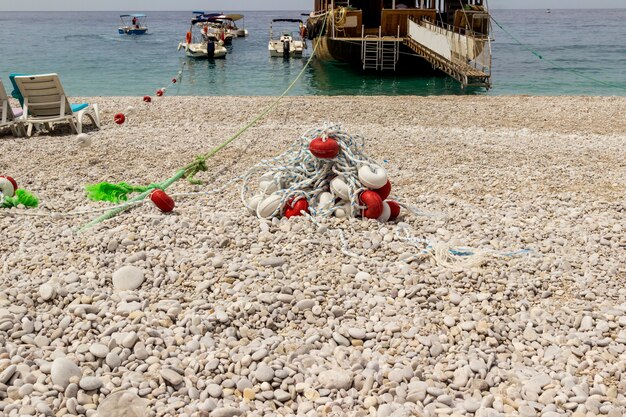 Foto ciottoli in riva al mare con la nave ormeggiata alla riva