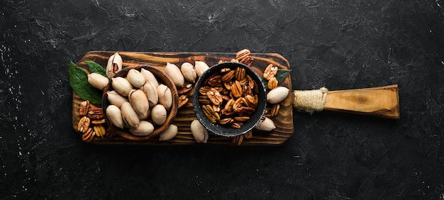 Pecan nut on black stone background. Assortment of pecans. Top preview. Free space for your text.