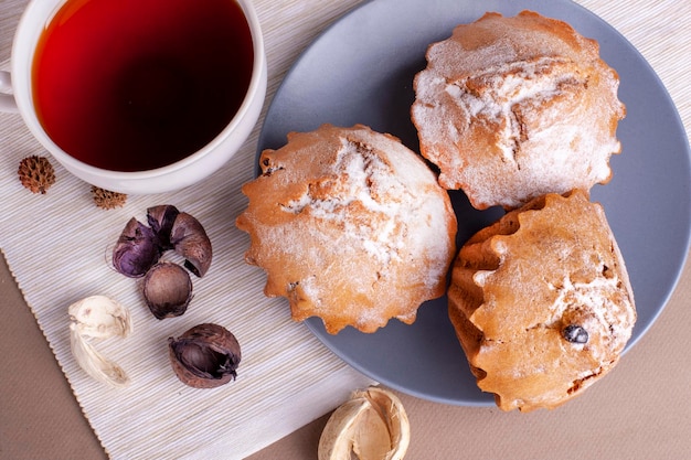 写真 カップケーキとプレートの灰色の背景に紅茶のカップとピーカン ナッツのマフィン