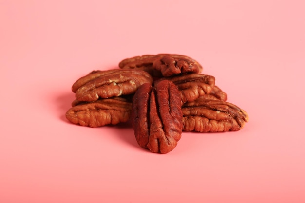 Pecan nuts on a pink background creative minimalist style healthy food