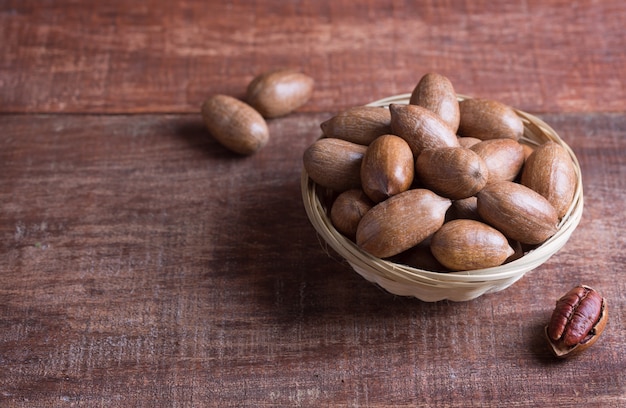 Pecannoten in een kom op een houten tafel