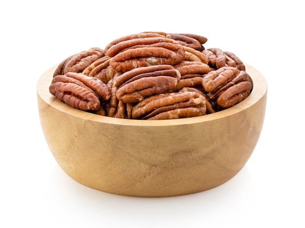 Pecans in wood bowl on a white