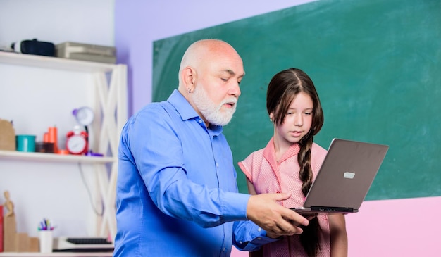 Pedagoog van digitale wetenschap Klein meisje met man tutor studie houd laptop online les Pedagoog vriendelijke soort Ervaren pedagoog Terug naar school Onderwijs kind Leraar helpen schoolmeisje