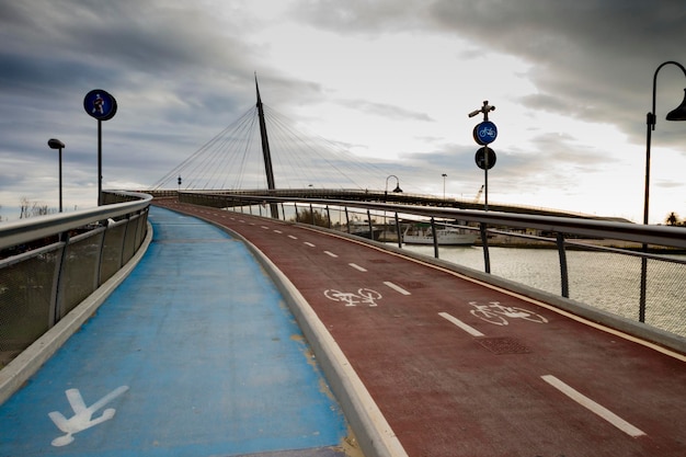 Foto segni per pedoni e biciclette sul ponte contro un cielo nuvoloso