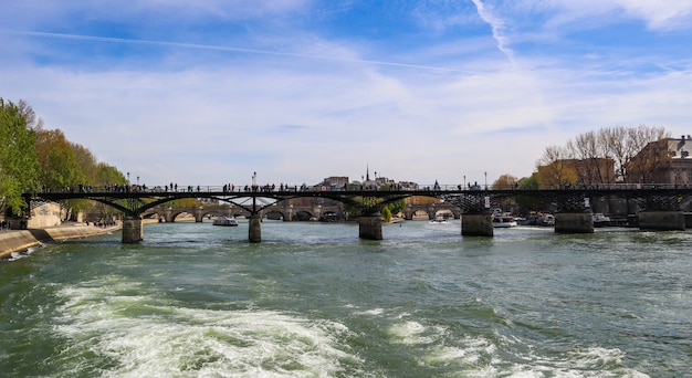 Pedestrian bridge pont des arts over seine river and historic buildings of paris france