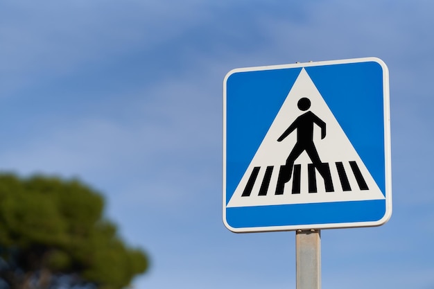 Pedestrian crossing traffic sign over blue sky