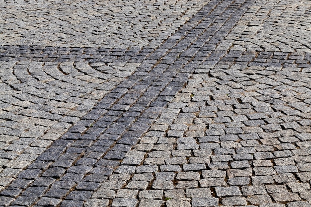 A pedestrian road in the city, made of small cobblestones of a square shape. On the surface there are some geometric figures. close-up of part of the pavement